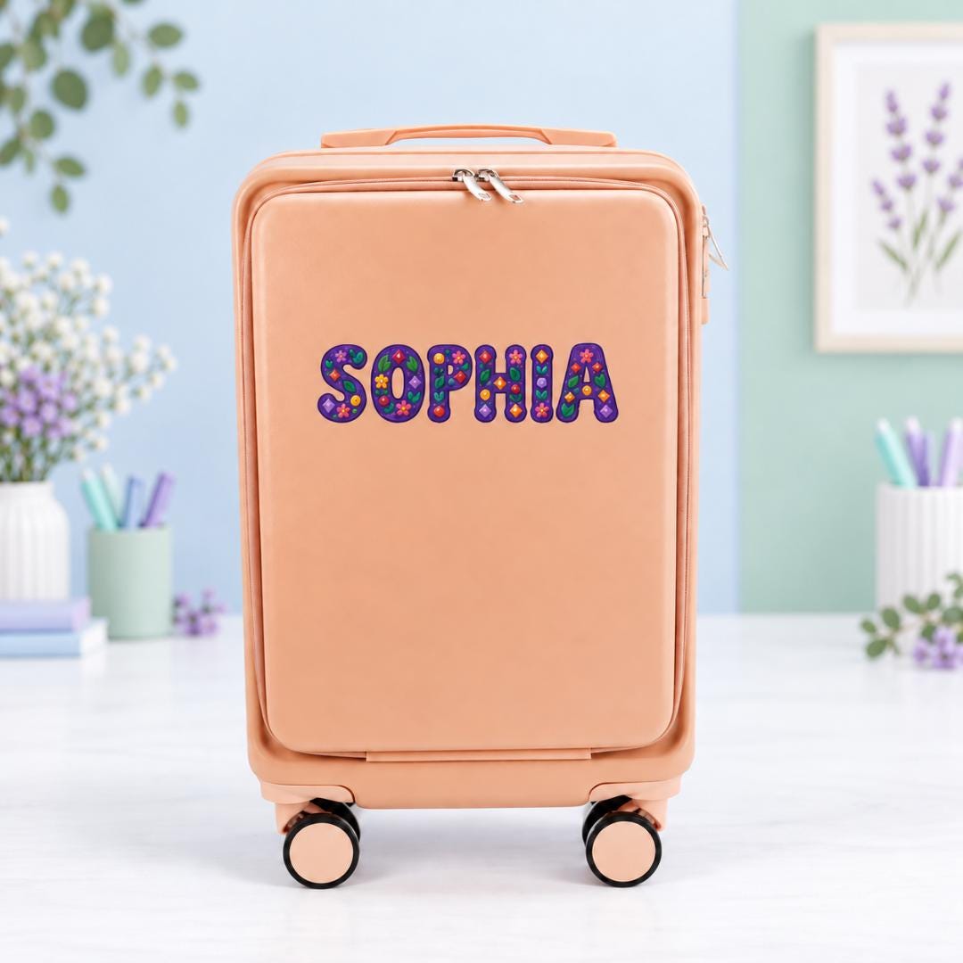 Pale pink personalized carry-on suitcase with example name Sophia in purple lettering decorated with colorful floral patterns