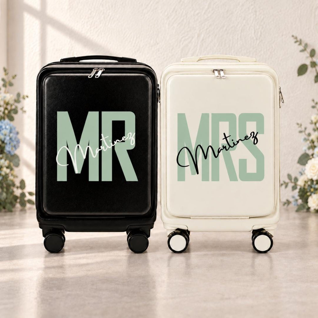 Black Mr and white Mrs carry-on suitcases with mint green lettering and an example personalized surname in script