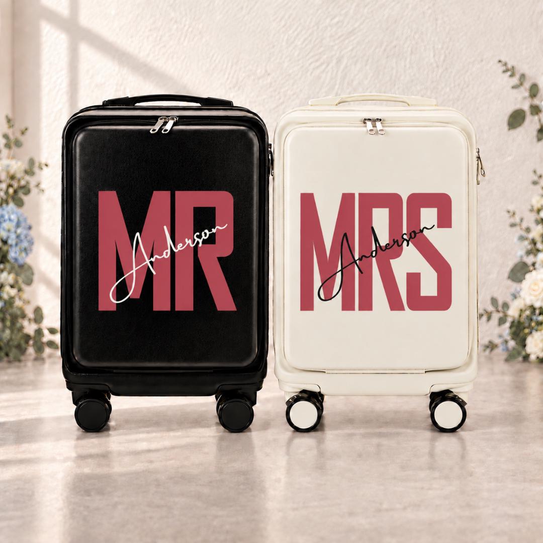 Black Mr and white Mrs carry-on suitcases with muted red lettering and an example personalized surname in script